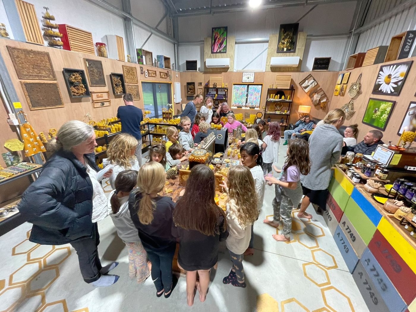 Students exploring beeswax creations at a honey education space